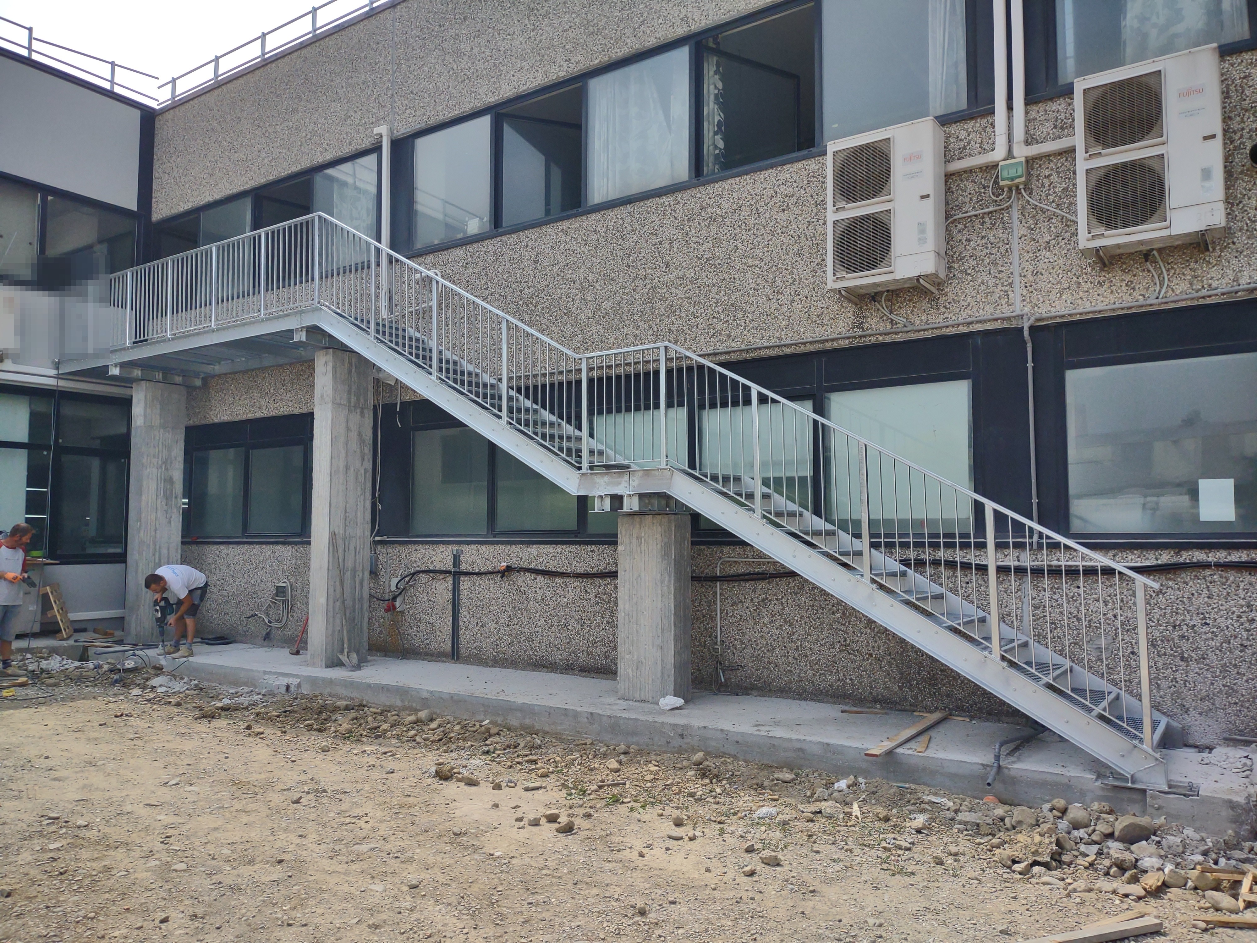 Scala esterna in acciaio con persone offuscate
